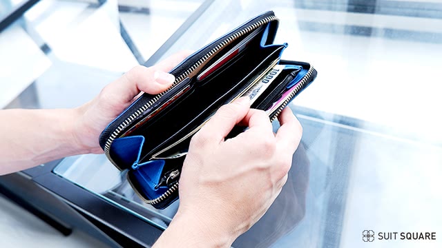 財布からお金を出している男性の手